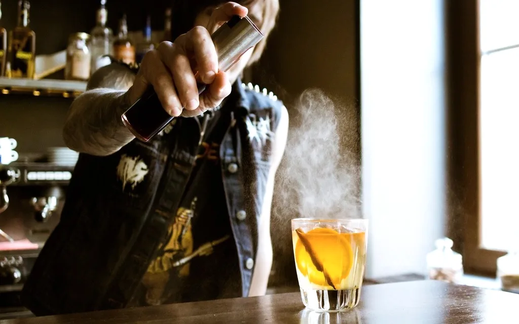 Bartender finalizando um drink no balcão de um bar