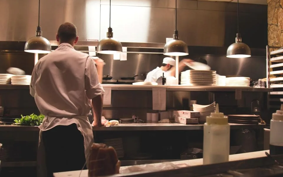 Equipe trabalhando na linha de uma cozinha profissional
